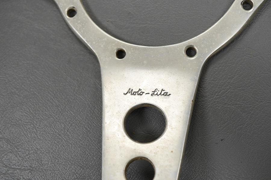 Racing ephemera, including; a Moto-lite steering wheel, a driver's leather cap, an enamelled Le Mans pilot’s radiator badge, signed photograph of Prince Michael Kent standing next to a 12 cylinder single seat racing car